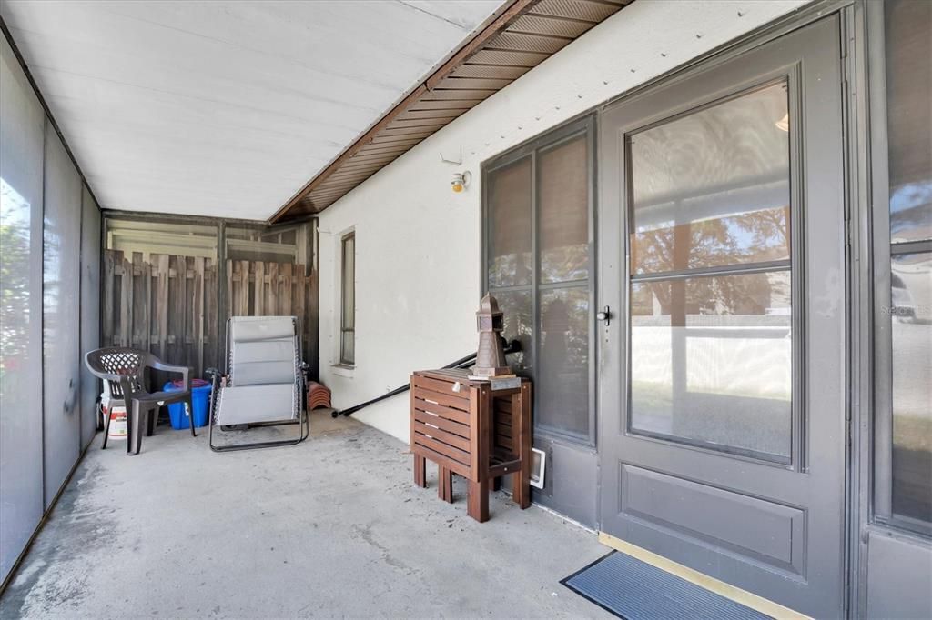 Back porch is spacious. In far corner you can see extra roof tiles if ever needed. All went well during recent storms but you have for any future issues. Door is from the bonus room, far window is Primary bedroom, and nice fencing for privacy from next door villa