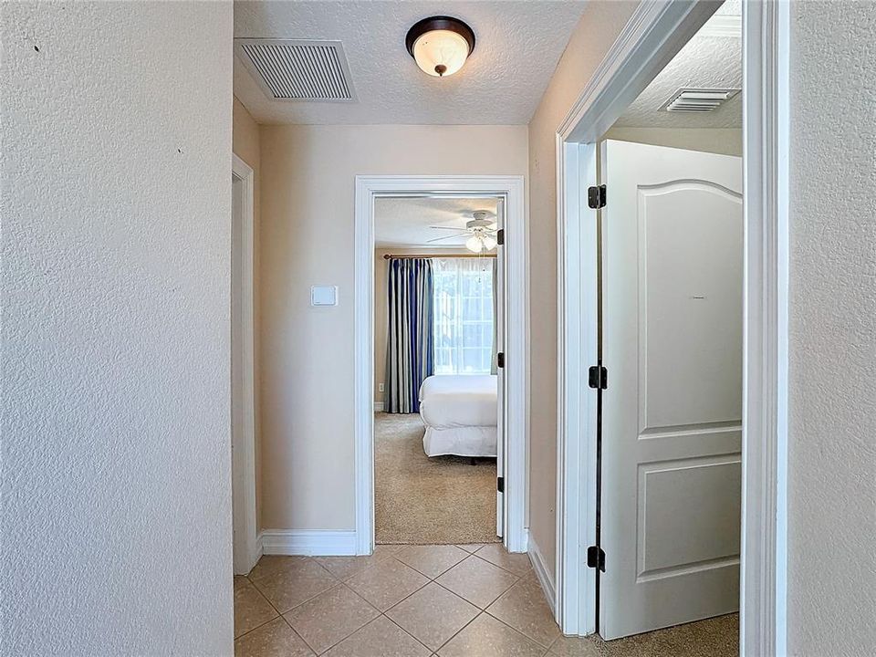 After going upstairs to the guest house above the garage, you'll see an entry way with a storage room on the right, bathroom on the left, and two bedrooms ahead.