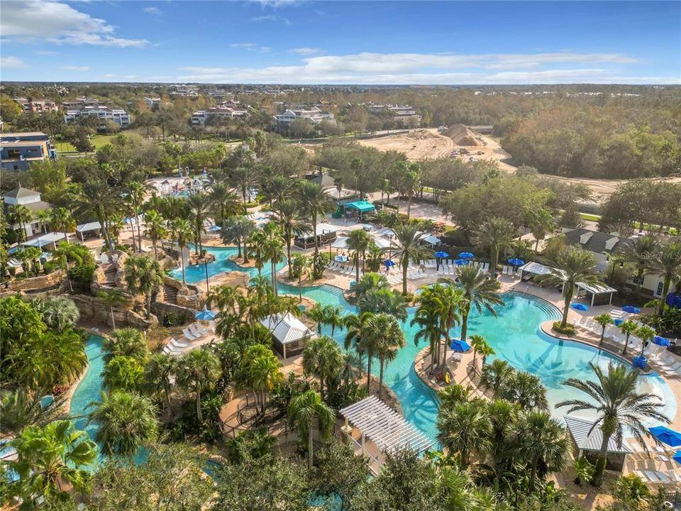 The edges of the lazy river are lined with tropical plants and palm trees, enhancing the feeling of being in a secluded paradise.