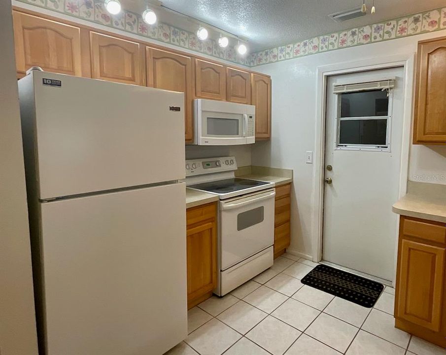 Refrigerator, range and door to garage