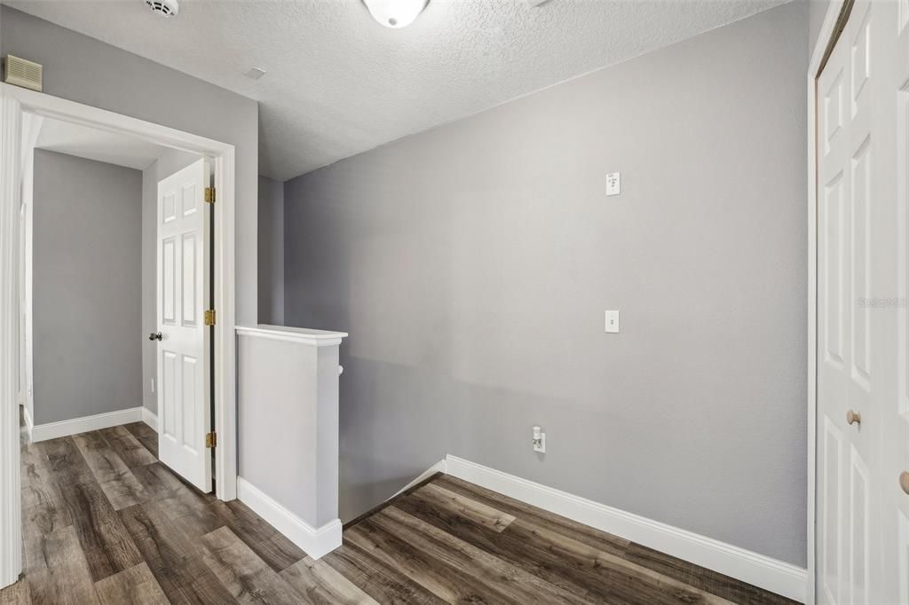 Upstairs hallway with laundry closet on the right.