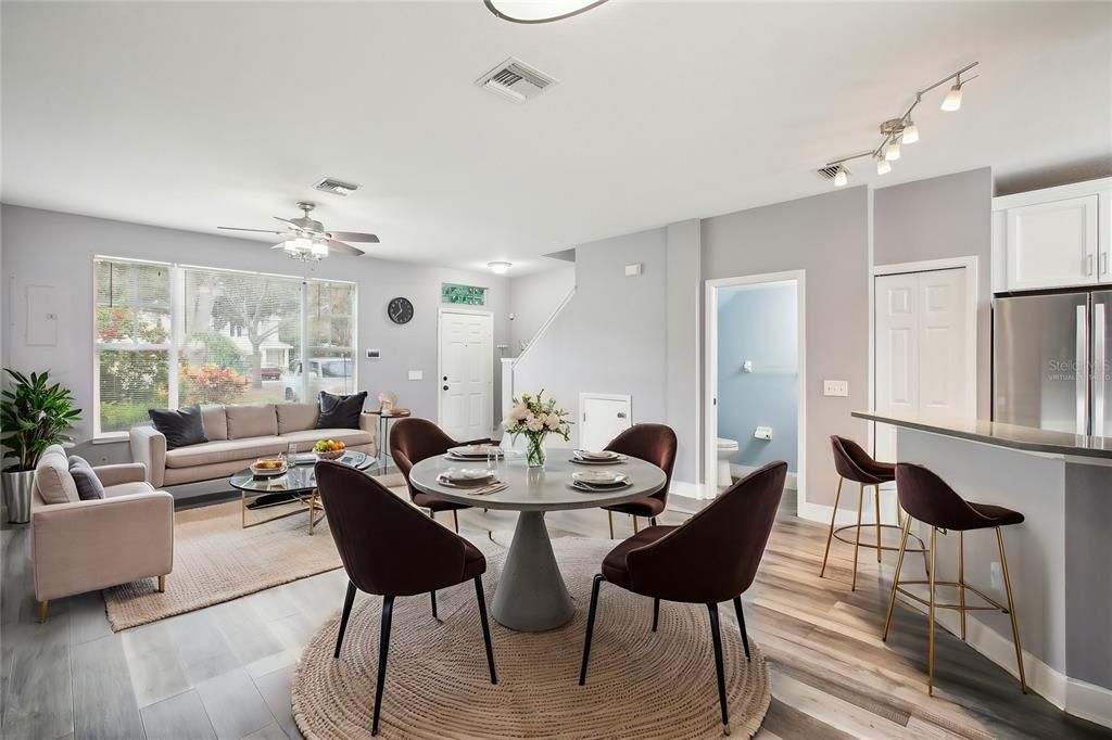 Virtually staged photo of the breakfast bar and living room/dining room area.