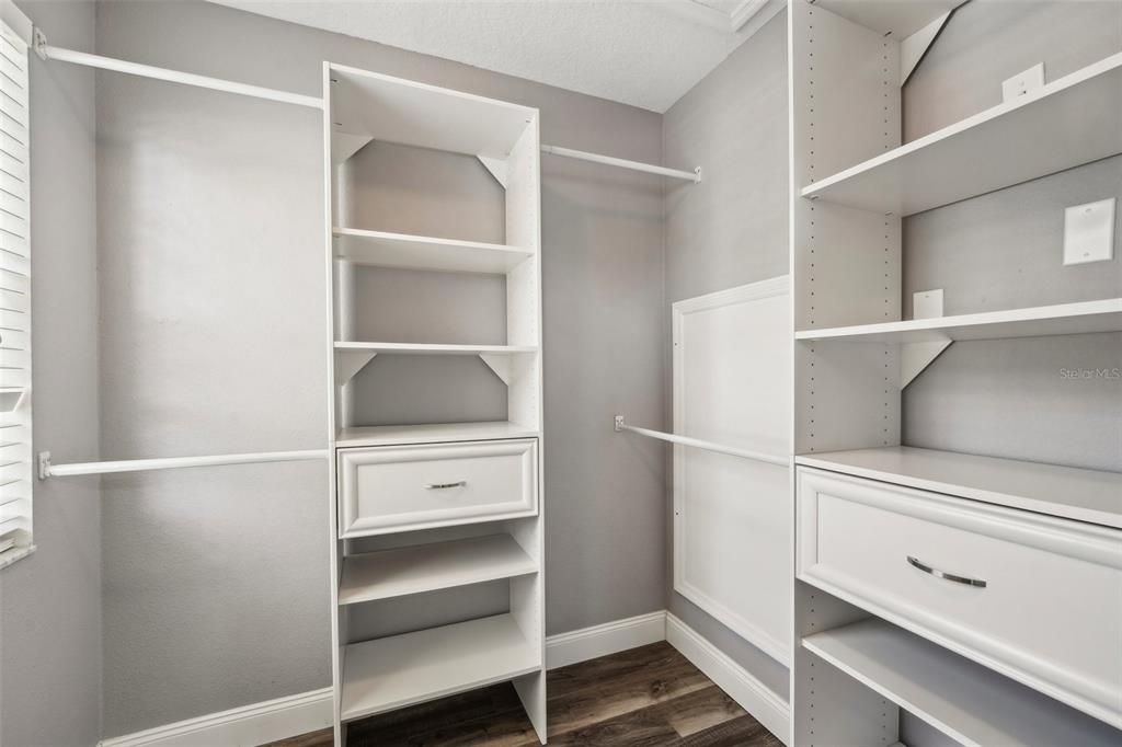 Master bedroom walk-in closet with closet system.