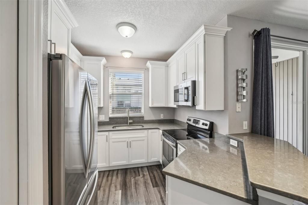 Updated kitchen with quartz countertops, stainless steel appliances, and a breakfast bar.