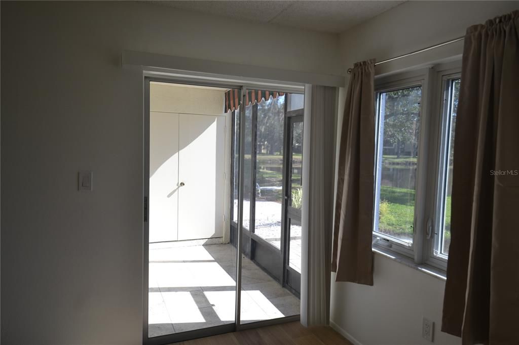 View of the patio and lake out the primary bedroom slider