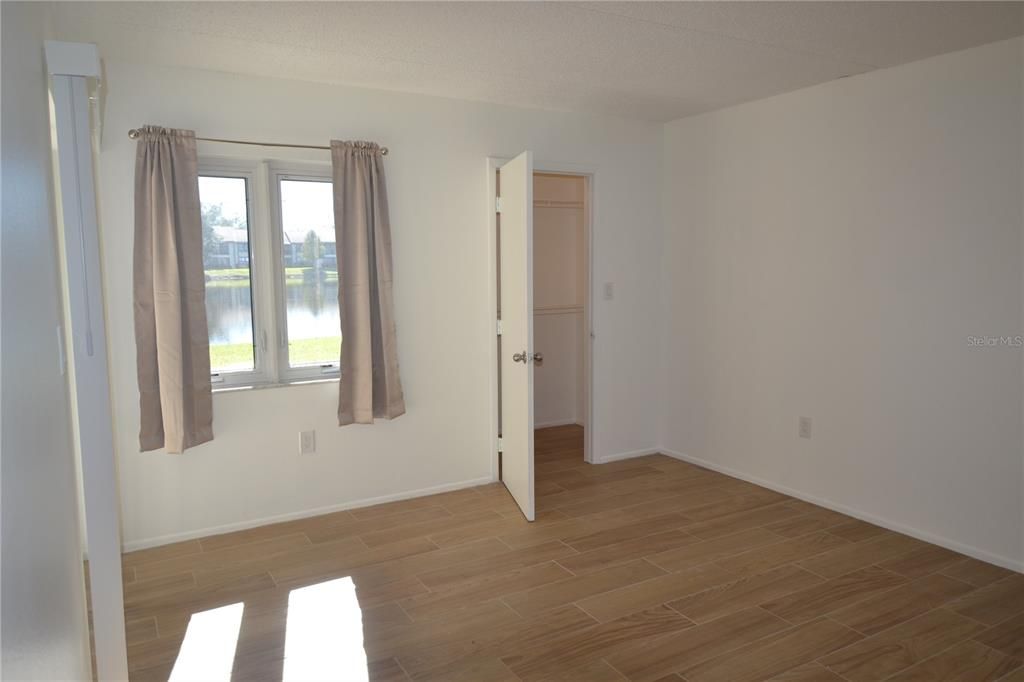 Another view of the primary bedroom with a view of the pond