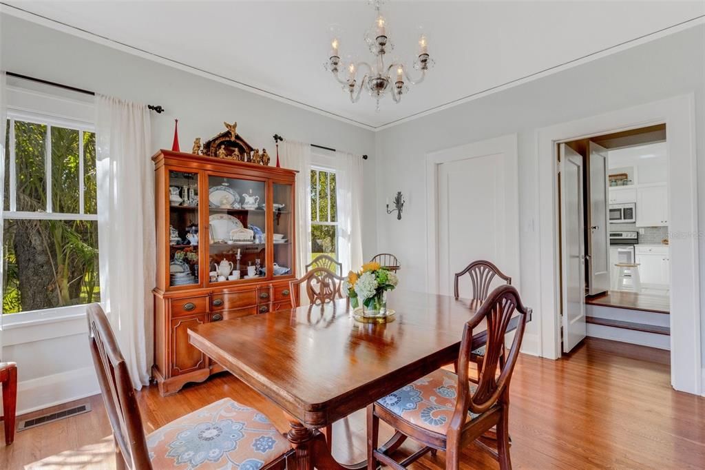 Access to the staircase with a peek of the kitchen beyond; the swinging door leads to the breakfast nook