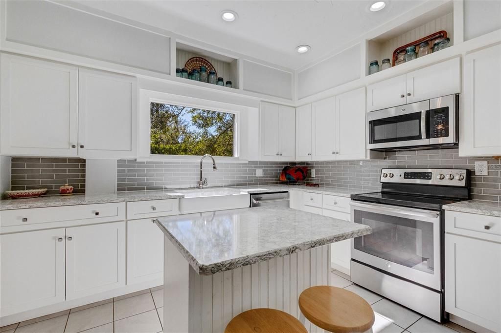 A big picture window and display niches add light and art to the design; gleaming gray and white quartz mimic the beauty of marble (without the upkeep!)