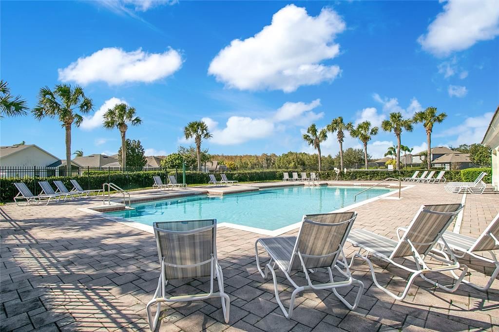 Resort-style community pool with ample seating and shaded areas, perfect for enjoying a relaxing day or socializing with neighbors.