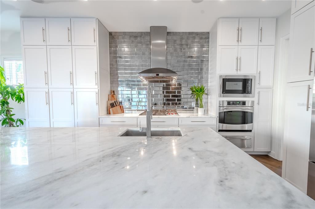 A statement in design: mirrored subway tile backsplash adds a touch of glamour to this chef’s kitchen.