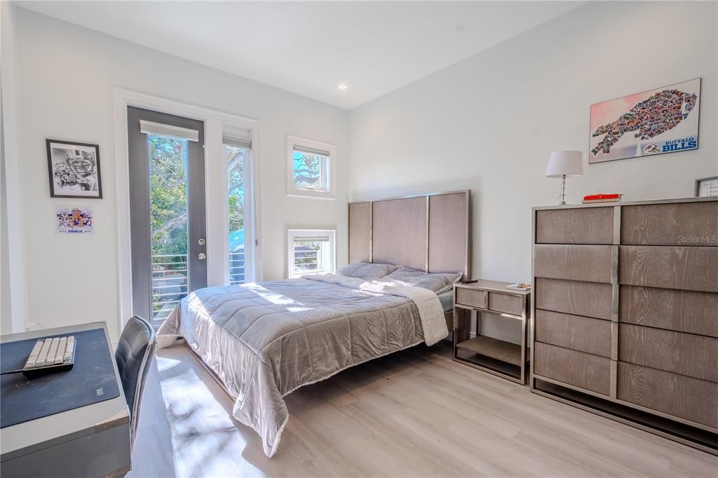 The 3rd bedroom features laminate flooring, neutral tones, a built-in closet, and a private balcony.