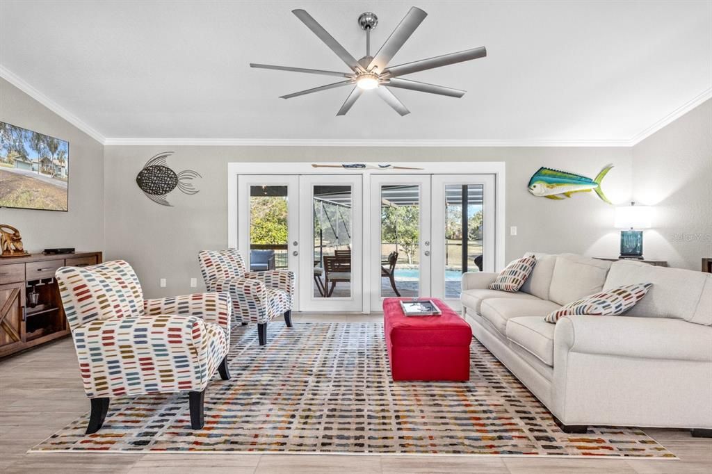 Living Room with double french doors to exterior living space, screened with heated pool