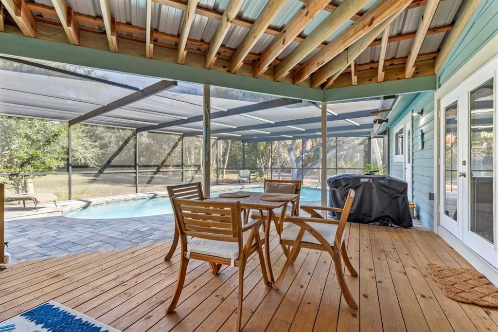 Rear covered screened dining area next to heated pool