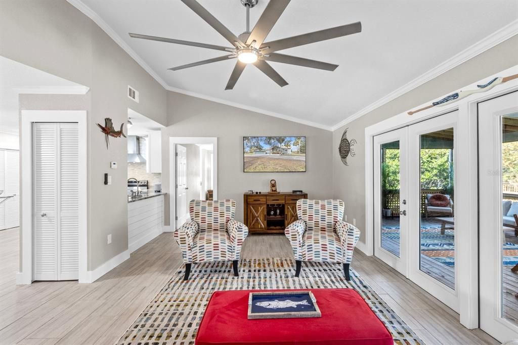 Another angle of Living Room with double french doors to outdoor living area, screened with heated pool