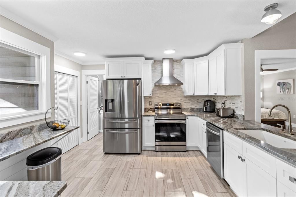 Kitchen with view into living room, breakfast bar, pantry and entry into utility room with washer and dryer