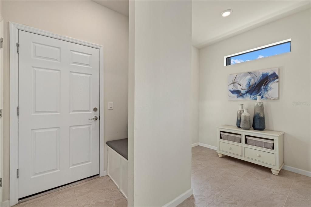 Entrance from the garage with bench and coat hooks