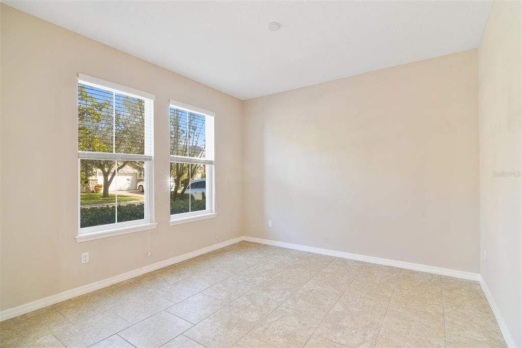 Versatile den space and half bathroom off the foyer offers the perfect space for a home office.