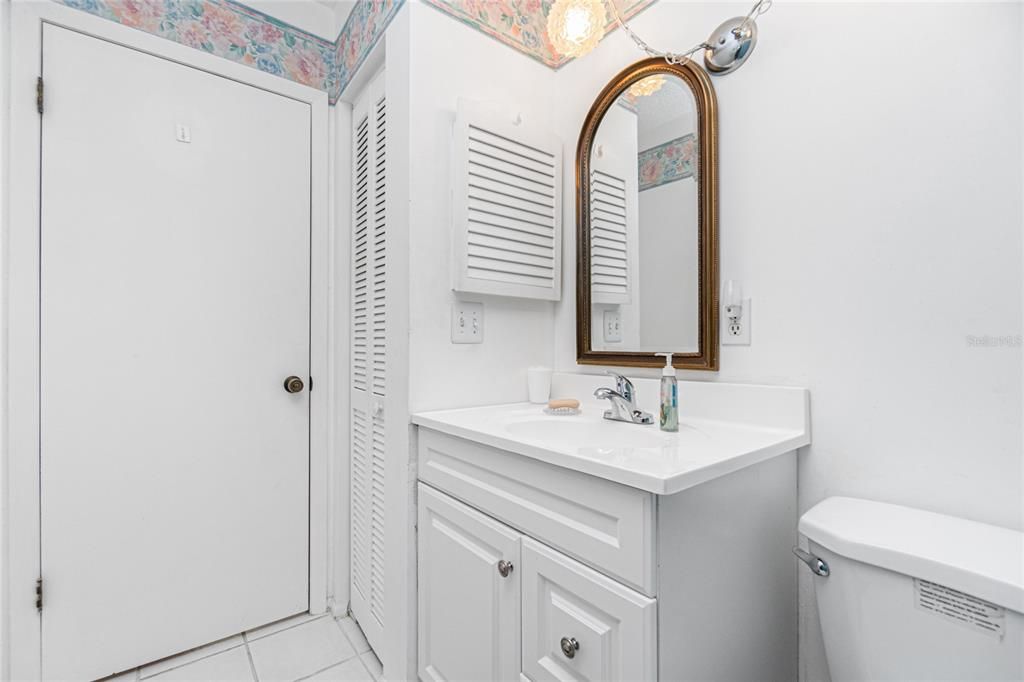 Guest bath has an updated vanity with a smooth surface counter top and linen closet foe added storage.