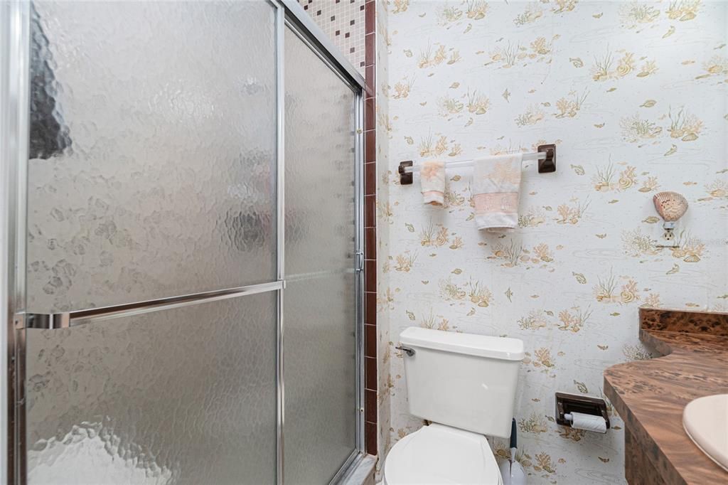 Main bathroom has a step in shower with glass sliding doors.