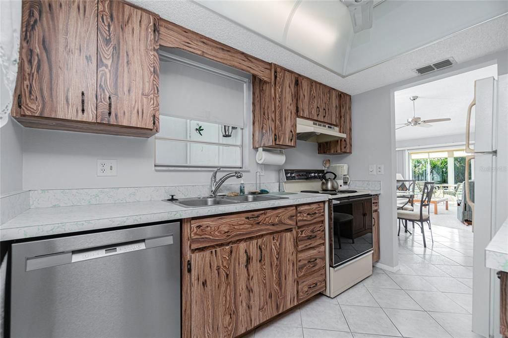 The kitchen also has a window above the sink and a ceiling fan.