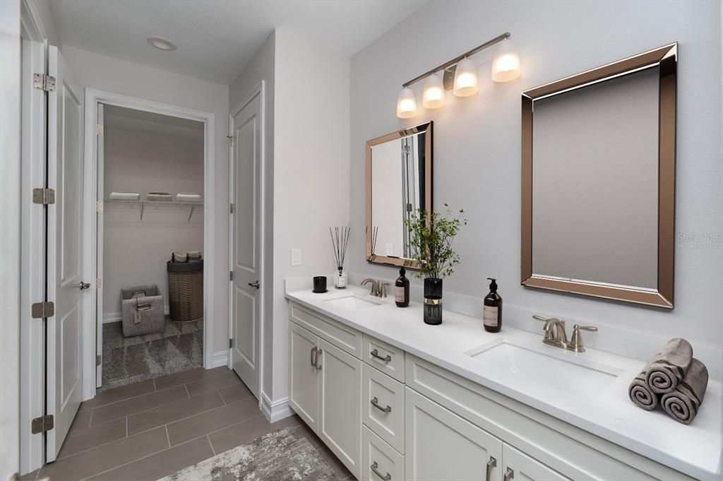 Virtually staged master bath with view of walk in closet