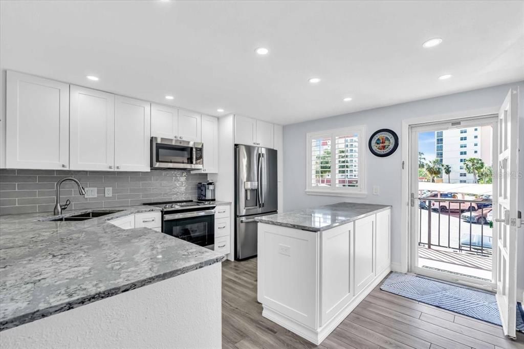 The kitchen has recessed lighting, plantation shutters, quartz counter tops with plenty of room for prepping and Stainless steel appliances