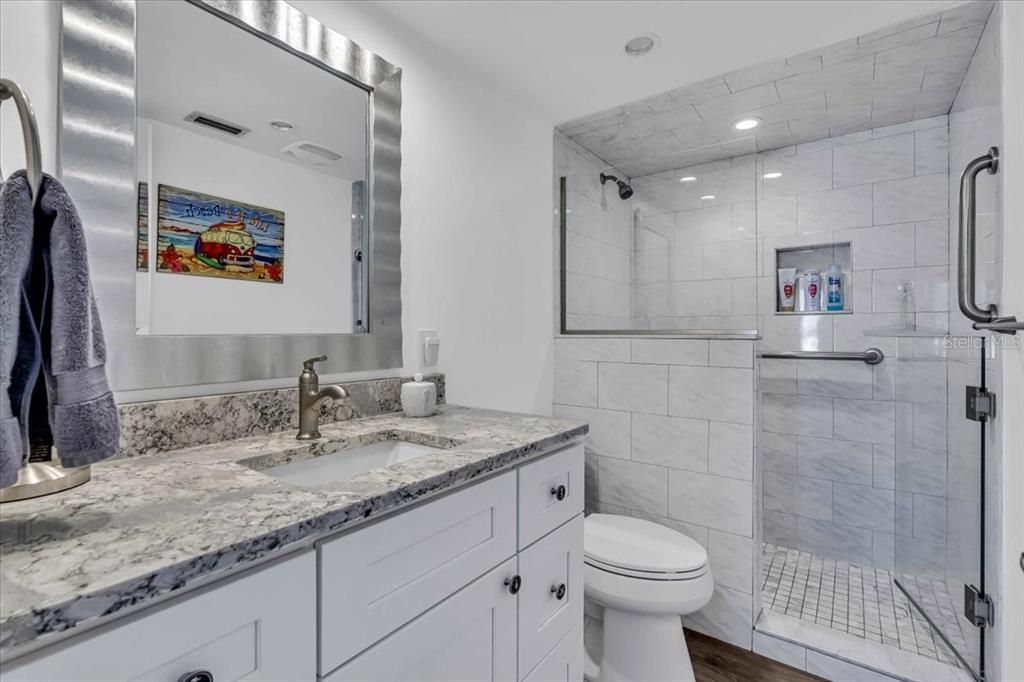 master bath has quartz vanity top and tiled walk in shower.