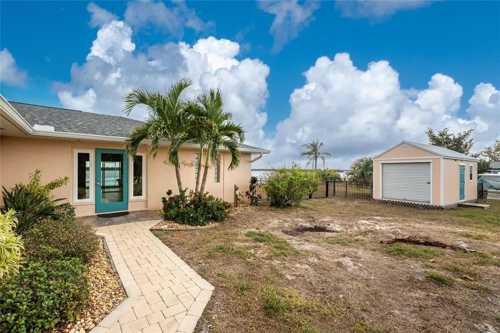 Front entry with paver sidewalk, shed & fenced sideyard.