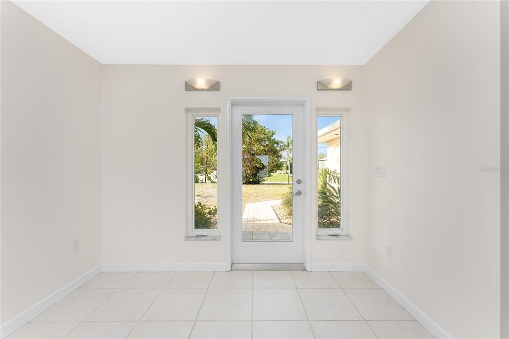 Front entry with impact doors & casement side windows to spacious foyer