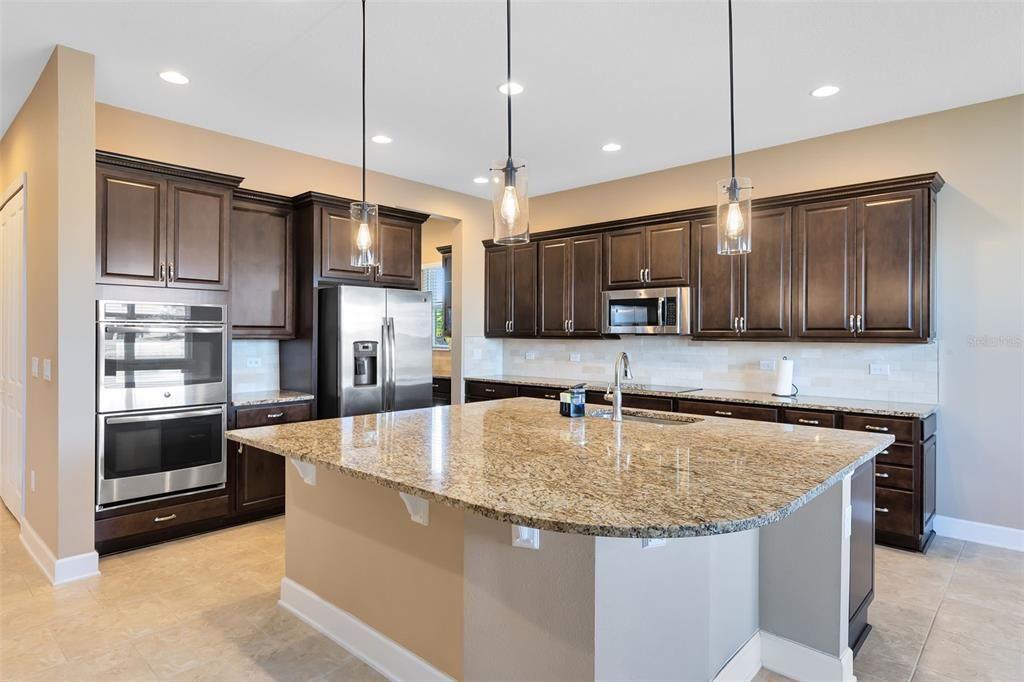 Boasting custom cabinets, striking granite countertops, an oversized Signature Harmon Island, and modern stainless steel appliances.