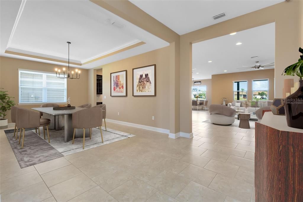 This photo has been virtually staged. A tray ceiling accents the formal dining room, adding a touch of traditional elegance.