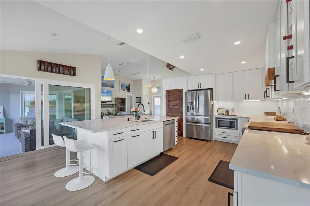 The kitchen has views to the Great Room and Family Room plus the water beyond.