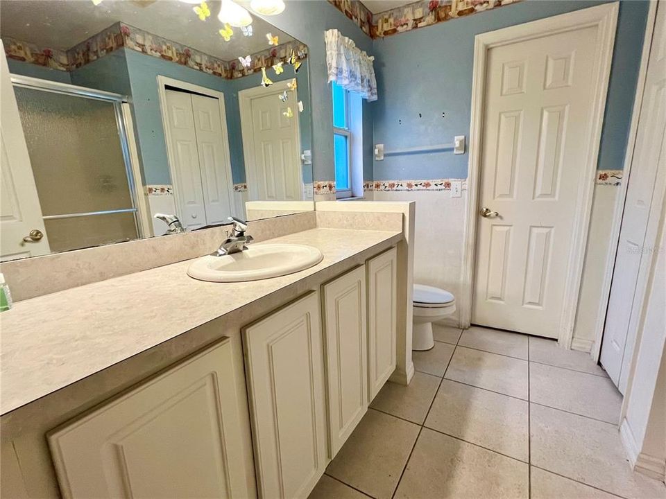 Master bathroom w/ door leading into walk-in closet