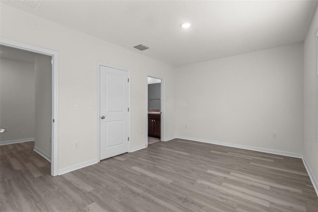 Primary Suite showing walk in closet and entry to En Suite Bathroom