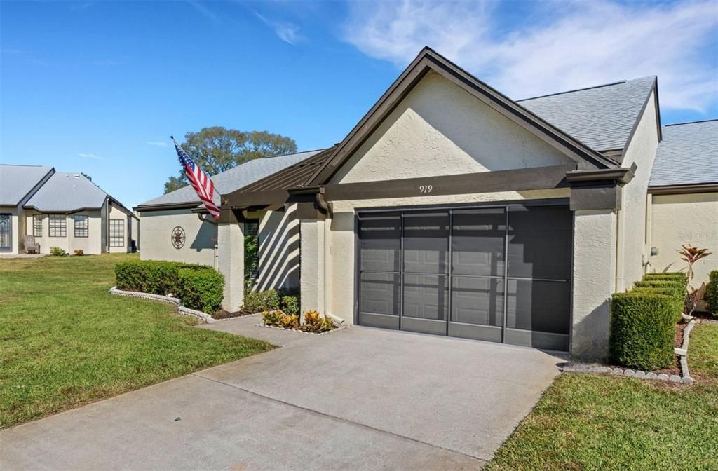 End villa with concrete block construction, newer roof & garage door~