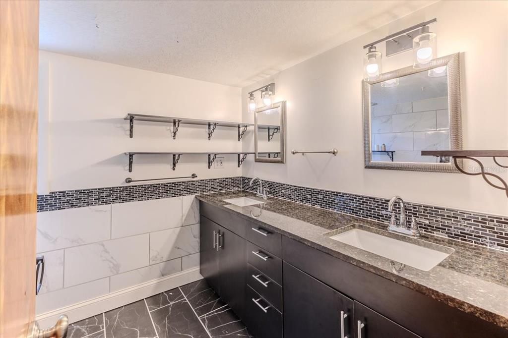 Remodeled Bathroom with Dual Sinks & Stone Cabinets