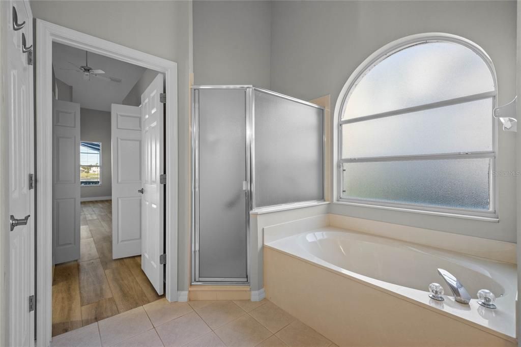 Primary BathroomRelax in the soaking garden tub surrounded by bright natural light.Spacious layout with dual vanities for added convenience.High ceilings enhance the open and airy feel.