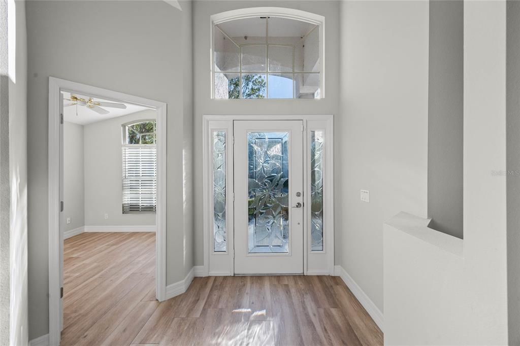 FoyerLight-filled entryway with a glass insert in the front door, offering street views and natural light.Open plan provides stunning sightlines to the lake, pool, and living room.Seamlessly connects to the living room, dining room, and 4th bedroom/office at the front of the home.