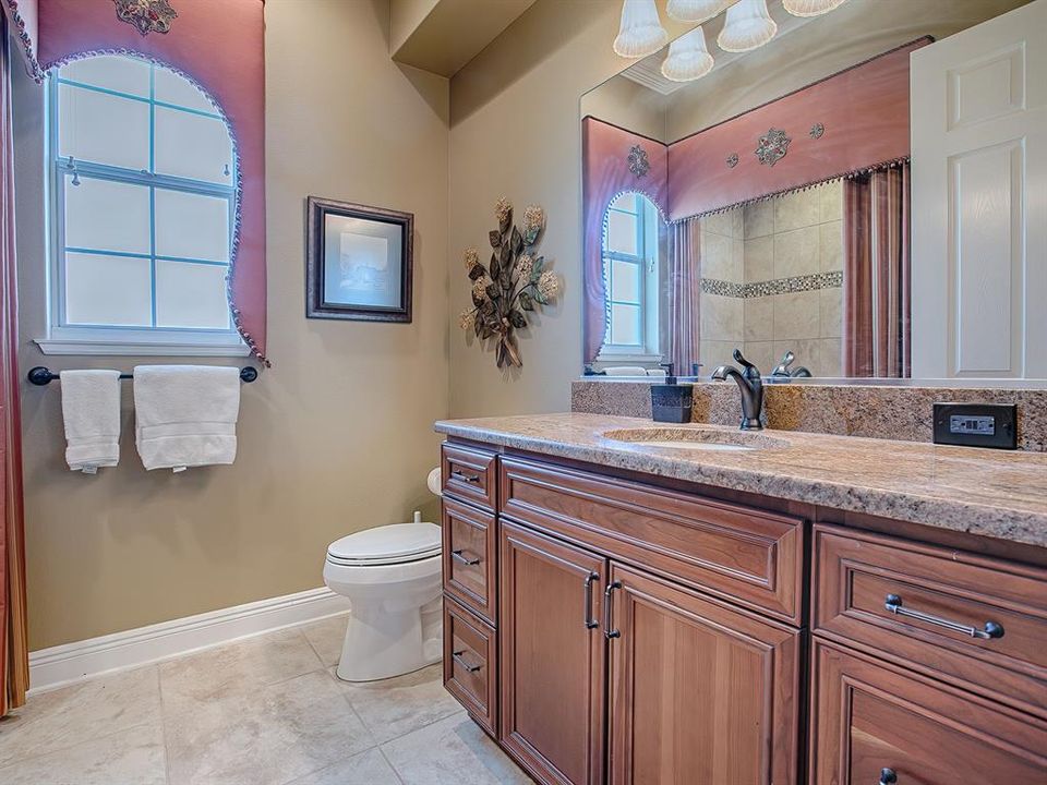 GUEST BATH WITH GRANITE COUNTERS AND TUB/SHOWER.