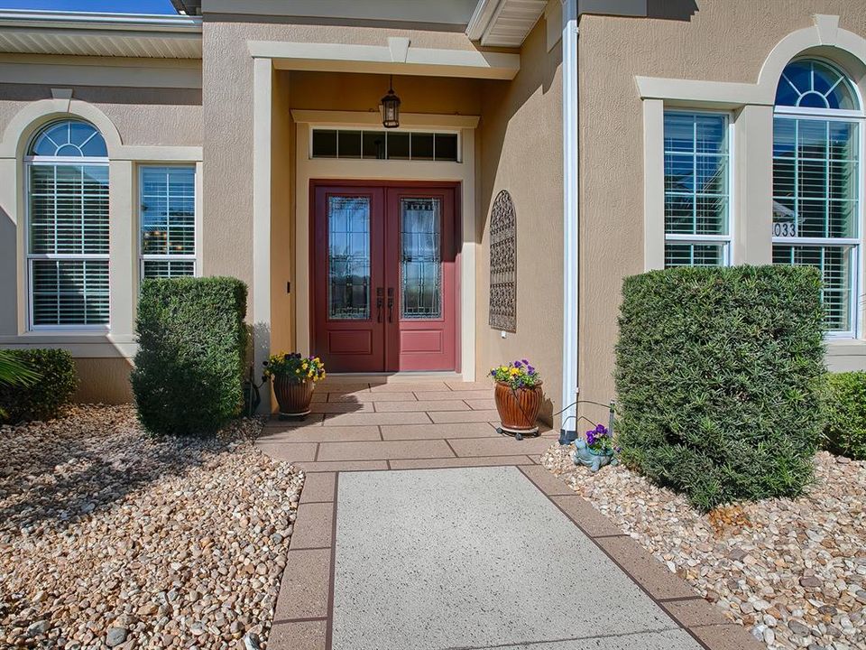 LOVELY ENTRANCE. DRIVE AND WALKWAY BEAUTIFULLY FINISHED WITH DECORATIVE, DURABLE CONCRETE COATING.