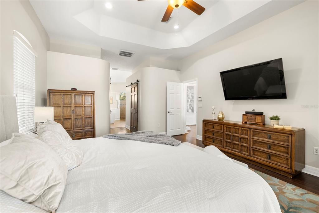 Primary bedroom showing barn doors into dual walk-in closets