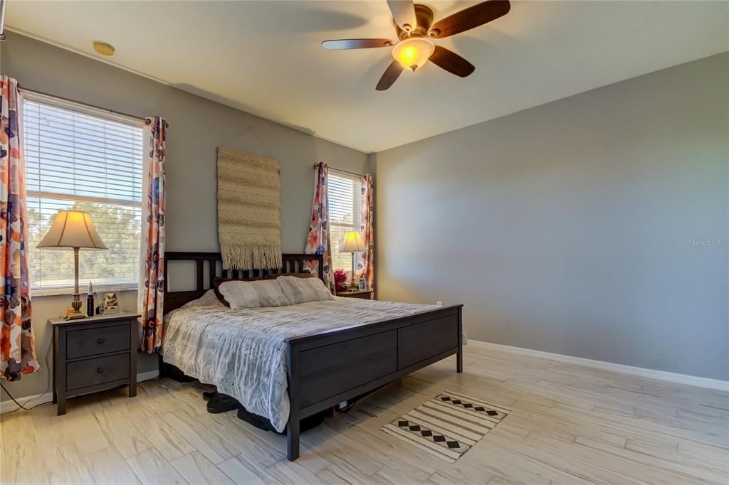 primary bedroom has sliding glass door to patio - tranquil views of the POND and conservation area