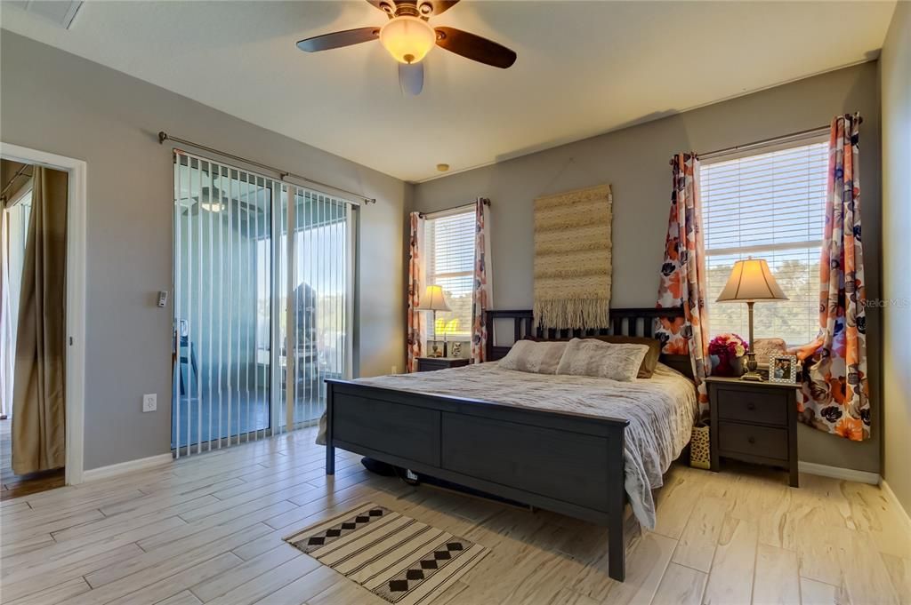 primary bedroom has sliding glass door to patio - tranquil views of the POND and conservation area