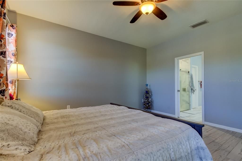 primary bedroom has sliding glass door to patio - tranquil views of the POND and conservation area