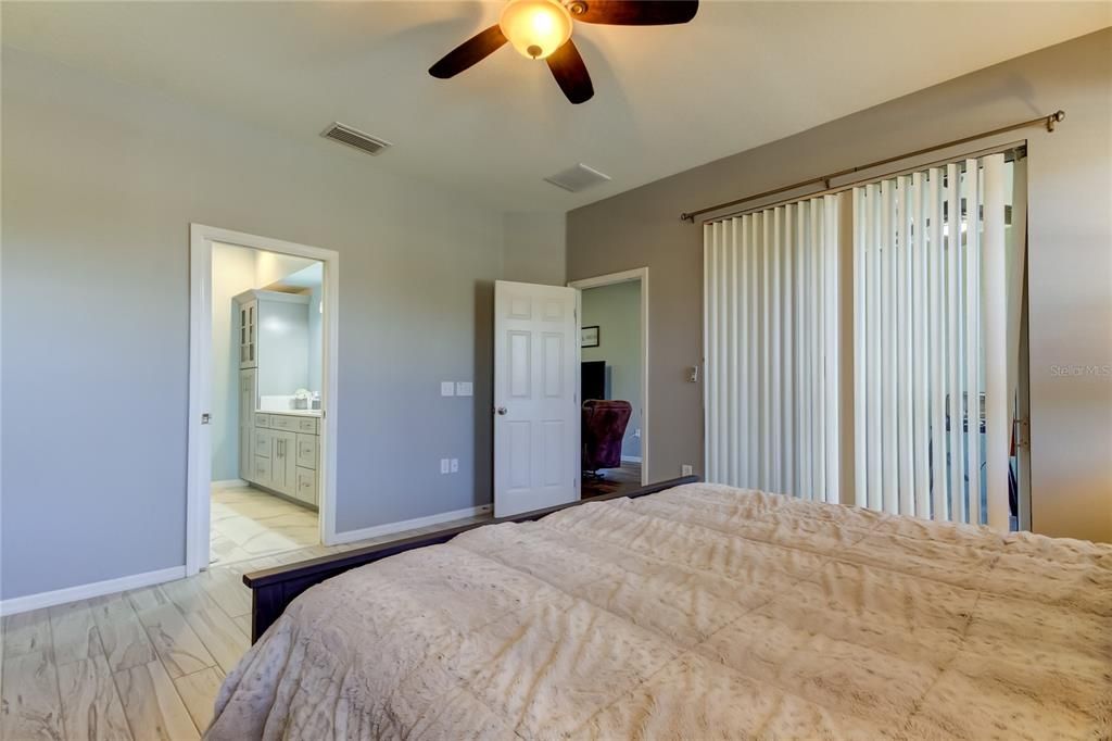 primary bedroom has sliding glass door to patio - tranquil views of the POND and conservation area