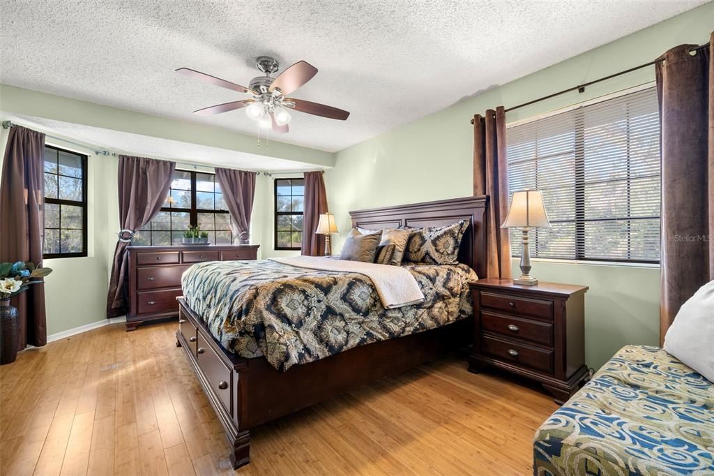 Spacious Primary Suite with hardwood floors and features a Bay window