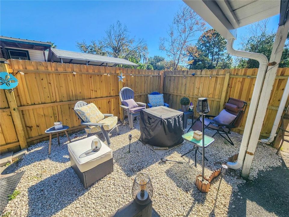 Brand-new graveled fire pit, surrounded by brand-new weather- and pressure-treated, stained wood privacy fence