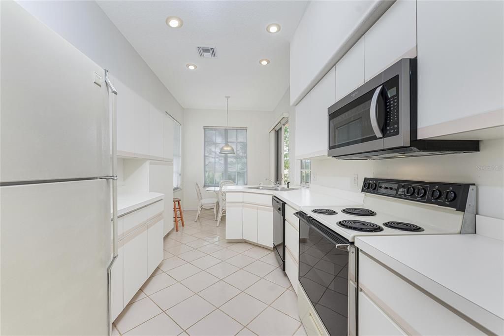 The kitchen as you enter from the dining room and living room. The patio doors to the right rear are to the lanai and the breakfast nook windows overlook the golf course.