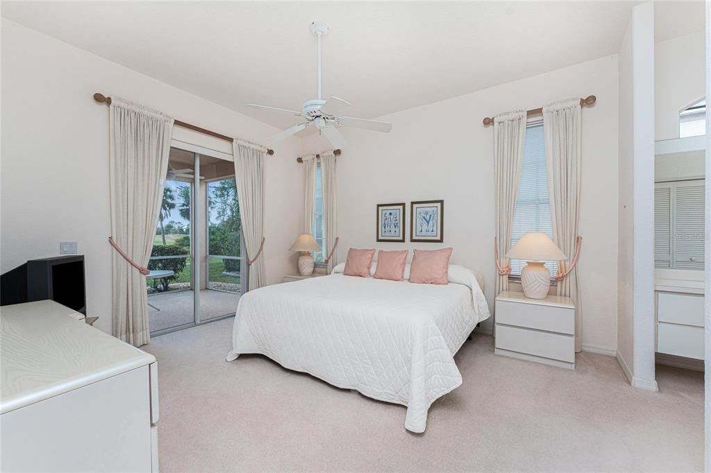 The master bedroom with patio doors to the lanai and views of the golf course.