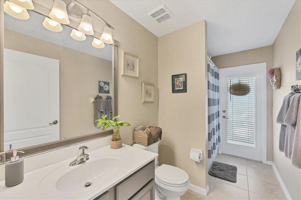 A shared guest bathroom doubles as a pool bath with easy access to the lanai.